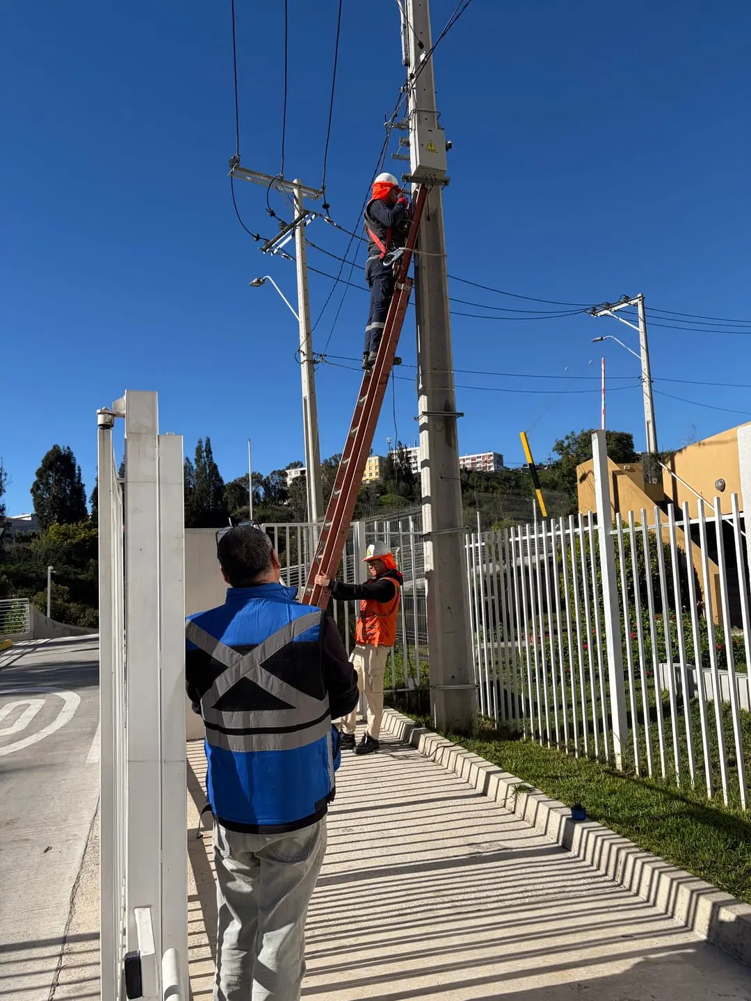 Equipo de SGR trabajando en altura sobre un poste eléctrico